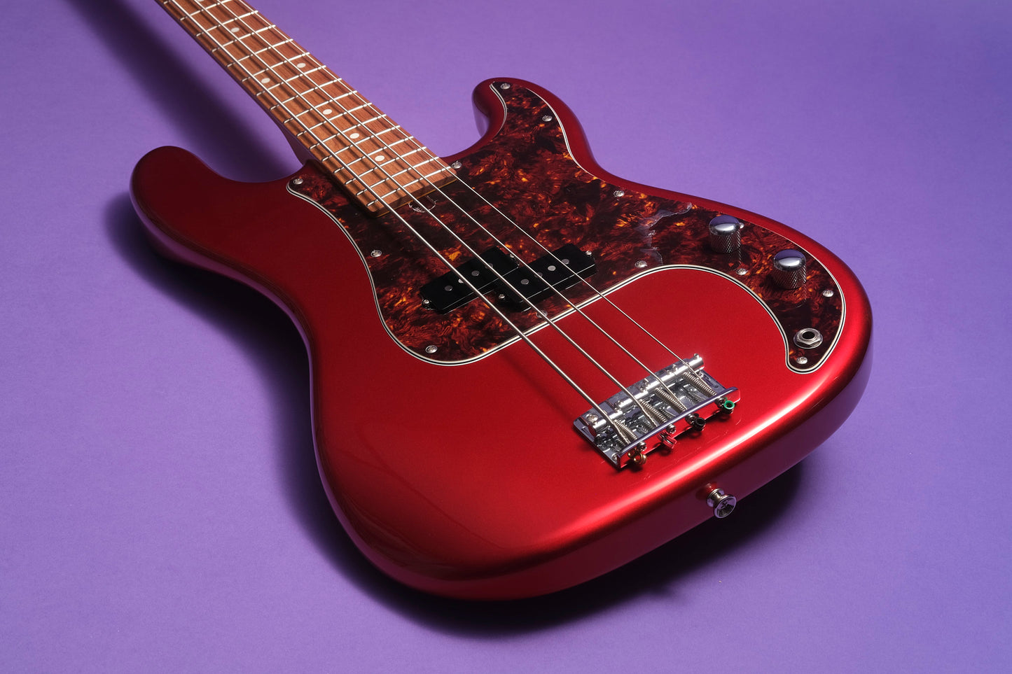 Red electric bass guitar on a purple background