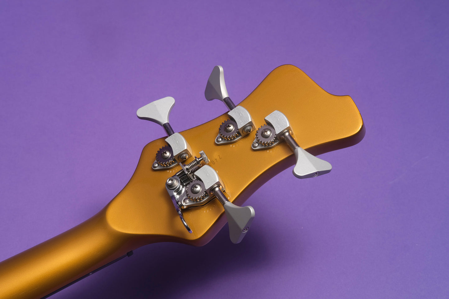 Guitar headstock with tuning pegs on a purple background