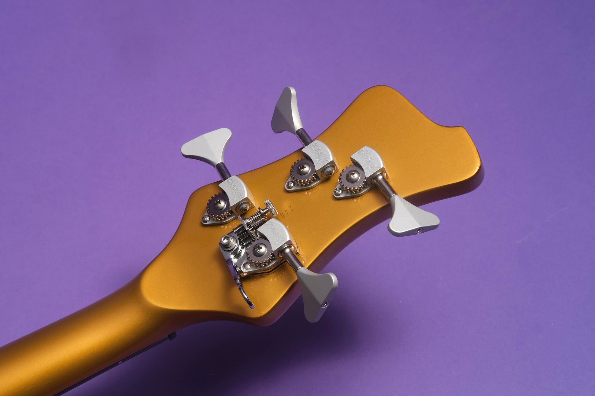 Guitar headstock with tuning pegs on a purple background