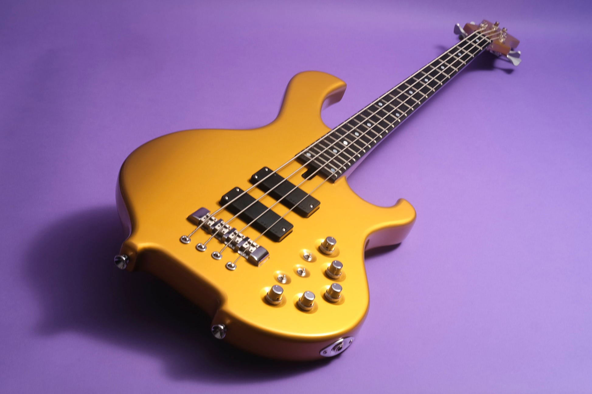 Gold bass guitar on a purple background