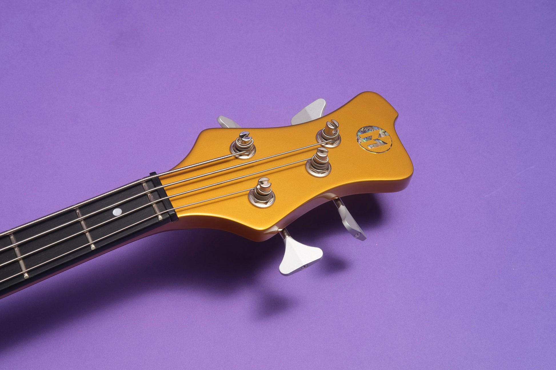 Guitar headstock with tuning pegs on a purple background