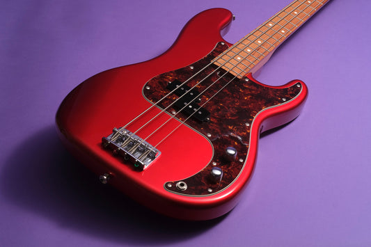 Red electric bass guitar on a purple background