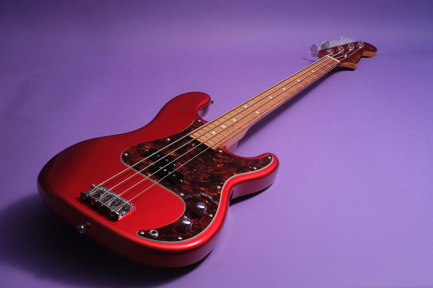 Red electric bass guitar on a purple background